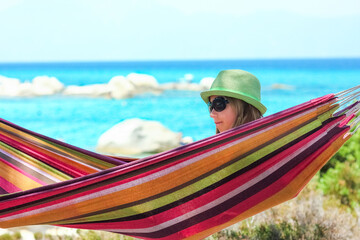 Wall Mural - happy child by the sea on hammock in greece background