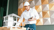 © Summit Art Creations - Professional caucasian architect engineer using tablet analysis house construction and checking model structure carefully with architectural model and equipment placed on meeting table. Manipulator.