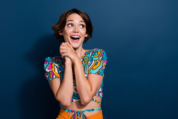 Wall Mural - Portrait of young beautiful lady with admiration looking copy space hands together birthday surprises isolated on blue color background