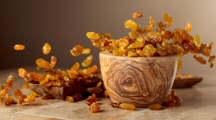 Poster - Yellow sultana raisins pour into a wooden bowl.