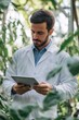 © Ева Поликарпова - A person in a lab coat looks at a tablet, possibly checking data or research findings