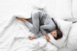 © Pixel-Shot - Young woman sleeping in bedroom, top view