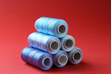 Wall Mural - Spools of colorful sewing threads on red background