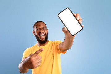 Wall Mural - new awesome mobile app. overjoyed african american guy pointing at smartphone with blank white scree