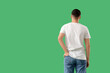 © Pixel-Shot - Young man in white t-shirt on green background, back view