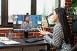 © DC Studio - Female employee speaks to her male manager remotely, discussing strategies in modern workspace. Asian businesswoman seated at desk, participating in a virtual meeting with caucasian businessman.