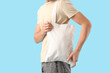© Pixel-Shot - Young man with white textile bag on blue background