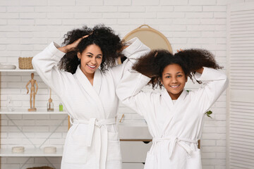 Sticker - Happy African-American mother and her cute daughter with healthy curly hair in bathroom