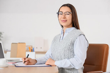 Sticker - Young businesswoman writing report at table in office