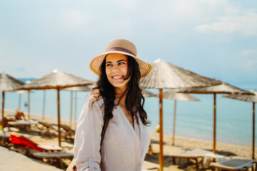 Wall Mural - Young caucasian woman is going to the beach with straw bag	
