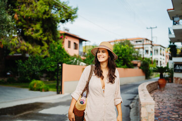 Young caucasian woman is going to the beach with straw bag	
