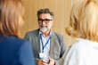 © Boris Jovanovic/Stocksy - Colleagues chat at the conference
