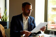 © Boris Jovanovic/Stocksy - Man revises papers in the restaurant