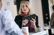 © Sean Locke/Stocksy - Business: Coworkers Discussing Graphics On Digital Tablet For Pr