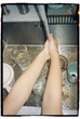© Luciano Spinelli/Stocksy - Point of view of anonymous hands washing Dishes in Kitchen Sink