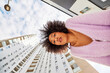 © Javier Díez/Stocksy - Black woman leaning forward against buildings