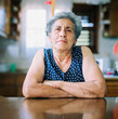© Nasos Zovoilis/Stocksy - Senior woman in a kitchen smiling with a confident posture