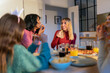 © Santi Nuñez/Stocksy - Woman enjoying pizza with friends around the table