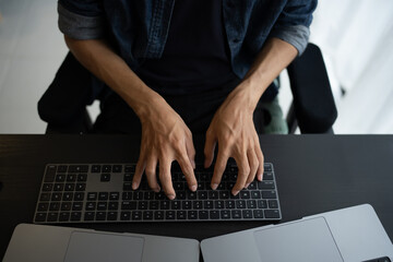 Asian man software engineer Working on Computer at office desk for writing program code IT Software Engineer finding errors tech support devops creating digital