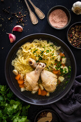 Sticker - Broth - chicken soup with noodles and vegetables on black table