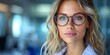 © Анастасия Гайкова - Young female doctor with blonde wavy hair, blue eyes, and stylish tortoiseshell glasses, exuding confidence and intelligence in a modern medical environment, showcasing professionalism and empathy