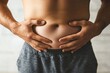 © Lubos Chlubny - Overweight man grabbing his belly fat