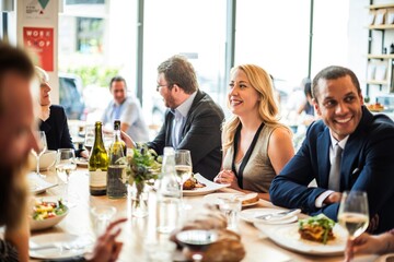 Wall Mural - group of people dining at a restaurant, enjoying food and conversation. diverse group, mixed genders