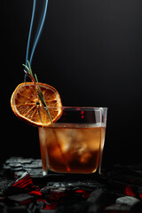 Wall Mural - Whiskey with ice, orange slice, and burning rosemary.