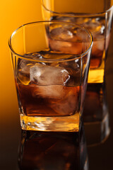 Wall Mural - Whiskey with ice on a reflective background.