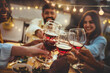 © Davide Angelini - People toasting red wine glasses on rooftop dinner party - Happy friends eating meat and drinking wineglass at restaurant patio - Food and beverage lifestyle concept with guys and girls dining outdoor