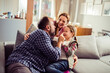 © Geber86 - Young family being playful on the couch in the living room of the home