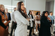 © Jacob Lund - Diverse group of professionals attentively listening during a business presentation at a corporate event, showcasing focus and engagement in a modern office environment