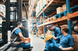 © Davor - Warehouse workers taking a break sitting near forklift in storage facility