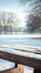 Poster - Close-up view of a snowy wooden surface highlighting a winter landscape and soft snowflakes falling in a tranquil setting
