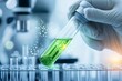 © Sanchai - A hand holding a test tube containing a glowing green liquid in a sterile laboratory