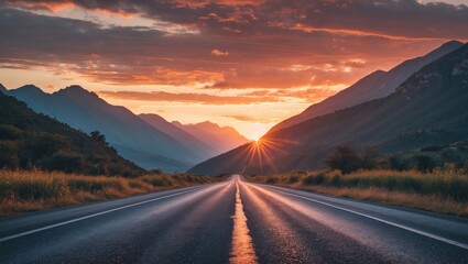 Wall Mural - Serene asphalt road leading towards majestic mountains under a vibrant sunset creating a picturesque travel destination scene.