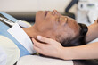 © Cavan Images - Doctor adjusting patients neck while laying down