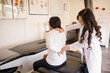 © Cavan Images - Patient showing doctor back pain