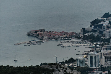 Evening view of the popular tourist town of Budva on the Adriatic coast in Montenegro, the Balkan Peninsula. View from a distance, from the pass. The old town and modern buildings