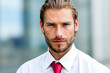 © Minerva Studio - Portrait of a confident businessman posing in front of an office building