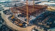 © nimaxs - Aerial view of a large construction site featuring a steel framework and heavy machinery, showcasing ongoing building activities.