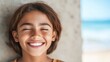 © daniel - Young girl with a huge smile enjoying a sunny day by the beach, radiating joy and happiness in a chaotic yet wonderful moment