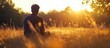 © STwul - Man meditating sunset field, peaceful nature background, wellness imagery