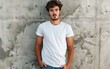 © nikolettamuhari - Young man in white t-shirt standing against textured gray wall