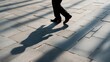 © fotofabrika - Walking figures cast shadows on cobblestone pavement during late afternoon light
