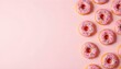 © Monster - Donuts rosados ​​esmerilados con chispas dispuestas sobre un fondo rosa claro. Los donuts tienen una base de color marrón dorado y están espaciados uniformemente