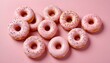 © Monster - Donuts rosados ​​esmerilados con chispas dispuestas sobre un fondo rosa claro. Los donuts tienen una base de color marrón dorado y están espaciados uniformemente