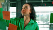 © Summit Art Creations - Portrait of smart professional hispanic businesswoman writes marketing ideas on glass board with colorful sticky notes. Young manager drawing mind map to analysis business plan. Closeup. Manipulator.