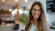 © Niphaphan - Businesswoman in formal wear, Hispanic, happily using her smartphone at her workstation