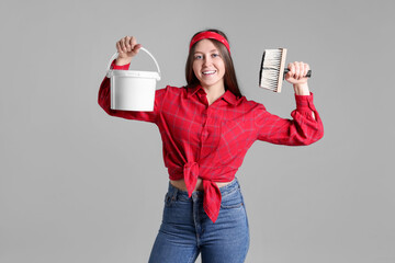 Wall Mural - Woman with brush and bucket of paint on light grey background